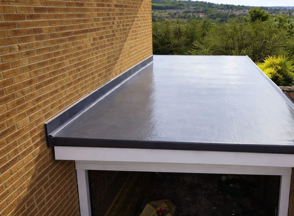 Finished seamless GRP flat roof beside a brick wall